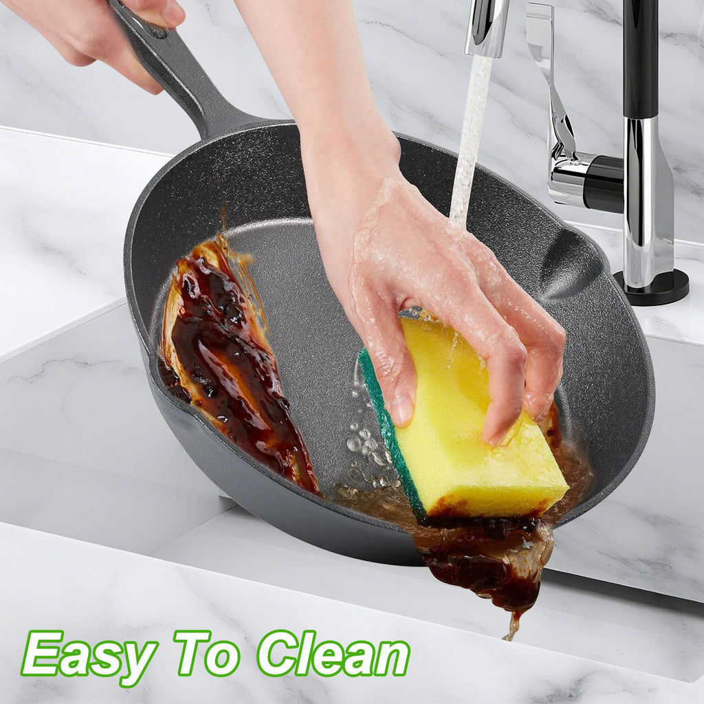 Person cleaning a greasy frying pan with a sponge in a kitchen setting.