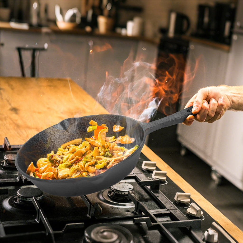 Person cooking stir-fry in a wok over a stove with flames