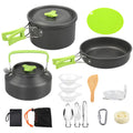 A 12-piece camping cookware set with a black non-stick finish and bright green accents, including a pot with lid, frying pan, kettle with lid, bowls, utensils, sponge, brush, and storage bag, arranged on a white background.