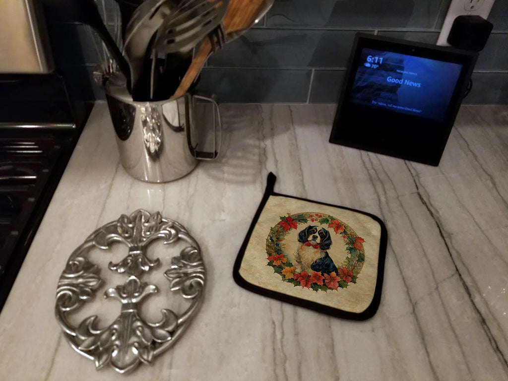Decorative trivet, potholder with dog design, and kitchen utensils on a marble countertop.