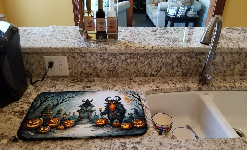 Decorative mat with Halloween design on a kitchen counter next to a sink.