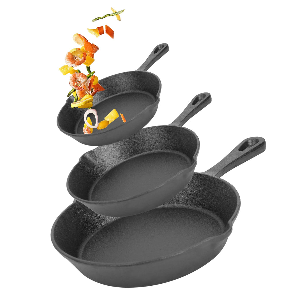 Three nested black cast iron skillets with handles, shown floating against a white background with decorative food pieces near the top.