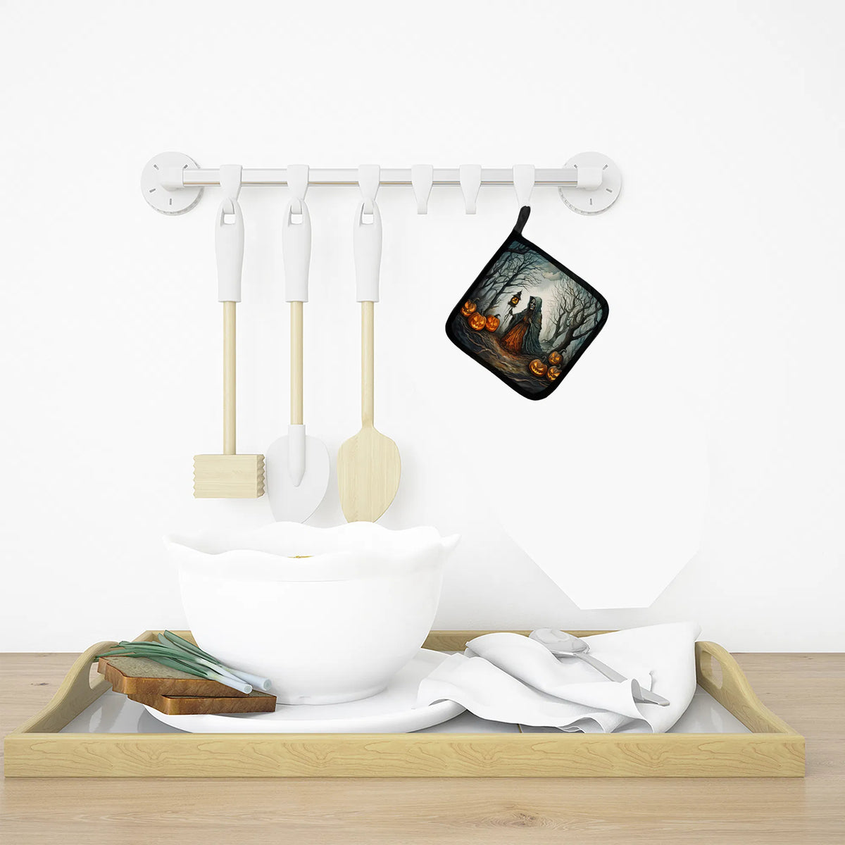 Kitchen utensils and pot holder on a magnetic strip with a tray below.