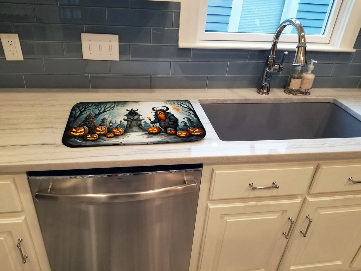 Halloween-themed mat on a kitchen counter with sink and cabinets in the background